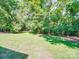 Expansive backyard features a lush green lawn and mature trees, offering privacy and shade at 135 Henry Putnam Dr, Cherryville, NC 28021