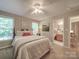 Light-filled bedroom with a queen bed, windows, and a view of the bathroom at 135 Henry Putnam Dr, Cherryville, NC 28021