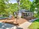 Inviting brick home with a charming front porch, black shutters, manicured landscaping, and a 'welcome' sign at 135 Henry Putnam Dr, Cherryville, NC 28021