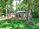Charming brick home with a covered front porch, well-manicured lawn, and mature trees at 135 Henry Putnam Dr, Cherryville, NC 28021