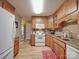 Cozy kitchen with wood cabinets, white appliances, and a light beige backsplash and countertops at 135 Henry Putnam Dr, Cherryville, NC 28021