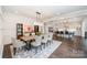 This dining room features dark hardwood floors, a contemporary light fixture, and opens up into the kitchen at 13602 Huntson Park Ln, Huntersville, NC 28078