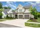 Beautiful two-story home featuring a stone facade, well-manicured lawn, a two-car garage, and professionally landscaped front yard at 13602 Huntson Park Ln, Huntersville, NC 28078