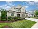 Attractive two-story home with stone accents, attached two-car garage, manicured lawn and a charming covered front porch at 13602 Huntson Park Ln, Huntersville, NC 28078