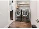 This laundry room features hardwood floors, modern gray washer and dryer, and shelving at 13602 Huntson Park Ln, Huntersville, NC 28078