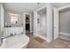 This main bathroom has a glass shower, a soaking tub, and double sinks at 13602 Huntson Park Ln, Huntersville, NC 28078