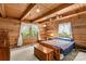 Inviting bedroom showcasing wood paneling, beamed ceiling, and colorful quilt at 140 Hearthstone Dr, Statesville, NC 28677