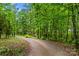 Winding gravel driveway surrounded by lush greenery and trees at 140 Hearthstone Dr, Statesville, NC 28677