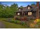 Inviting log cabin with a covered porch and vibrant landscaping, perfect for enjoying the outdoors at 140 Hearthstone Dr, Statesville, NC 28677