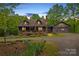 Charming log cabin home with a well-manicured lawn and beautiful flower beds, offering a serene setting at 140 Hearthstone Dr, Statesville, NC 28677