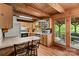 Rustic kitchen featuring wood cabinets, floors, and exposed beam ceiling and an outdoor patio area at 140 Hearthstone Dr, Statesville, NC 28677