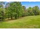 Expansive grassy field surrounded by lush trees, offering a serene natural setting at 140 Hearthstone Dr, Statesville, NC 28677