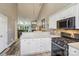 Kitchen with white cabinets, modern appliances and a view into the living room with a fireplace at 14118 Yachtsman Harbor Dr, Charlotte, NC 28278