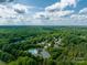 Scenic aerial view of a neighborhood with lush green trees, a pool, playground and community parking at 1465 Porters Ct, Concord, NC 28025