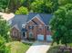 Brick home with a three car garage and a well maintained lawn from an aerial point of view at 1465 Porters Ct, Concord, NC 28025