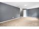 Large bedroom featuring plush carpet, light fixture, a door, and freshly painted gray walls at 1465 Porters Ct, Concord, NC 28025