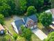 Aerial view of a two-story brick home with a well-manicured lawn, long driveway and two-car garage at 1465 Porters Ct, Concord, NC 28025