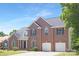 Charming two-story brick home with a well-maintained lawn, attached two-car garage, and classic architectural details at 1465 Porters Ct, Concord, NC 28025