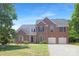 Charming two-story brick home with a well-maintained lawn, attached two-car garage, and classic architectural details at 1465 Porters Ct, Concord, NC 28025