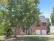Charming two-story brick home with a well-maintained lawn, attached two-car garage, and classic architectural details at 1465 Porters Ct, Concord, NC 28025