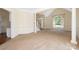 Open living room featuring neutral carpet, columns, a staircase, and a large window at 1465 Porters Ct, Concord, NC 28025