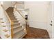 Elegant carpeted staircase with white railing and wooden banister, leading to the second floor, and hardwood floors at 1465 Porters Ct, Concord, NC 28025