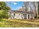 Charming one-story home with a spacious backyard and wooden stairs leading to a rear entrance, surrounded by nature at 1637 Sumner Dr, Rock Hill, SC 29732