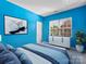Modern bedroom featuring bright blue walls, comfortable bed, and natural light from a large window at 1821 Ethel Guest Ln, Charlotte, NC 28206