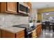 A modern kitchen featuring wooden cabinets, granite countertops, stainless steel appliances, and an adjacent dining area at 1821 Ethel Guest Ln, Charlotte, NC 28206