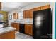 Well-lit kitchen with wood cabinets, black appliances, and gray countertops at 1821 Ethel Guest Ln, Charlotte, NC 28206