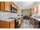A modern kitchen featuring wooden cabinets, granite countertops, stainless steel appliances, and an adjacent dining area at 1821 Ethel Guest Ln, Charlotte, NC 28206
