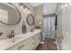 Bathroom featuring double sinks, a decorative mirror, and a bathtub with a shower curtain at 195 Antler Dr, Statesville, NC 28625
