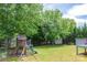 A delightful backyard with mature trees, playground set, and shed, perfect for Gathering fun and outdoor adventures at 206 Pine Meadow St, Hickory, NC 28601
