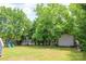 Expansive backyard featuring mature trees, a storage shed, a playset and trampoline, offering space for recreation at 206 Pine Meadow St, Hickory, NC 28601