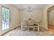 Bright dining area with a classic chandelier, tile flooring, and access to a deck through a glass door at 206 Pine Meadow St, Hickory, NC 28601