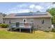 Back exterior view of house showing solar panels, deck, siding, and manicured lawn at 206 Pine Meadow St, Hickory, NC 28601