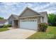 Home featuring a brick-accented two-car garage and well-maintained lawn at 206 Pine Meadow St, Hickory, NC 28601