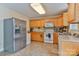 A well-maintained kitchen featuring tile floors, stainless steel refrigerator, and wood cabinets at 206 Pine Meadow St, Hickory, NC 28601