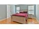 Bedroom featuring a full-sized bed, wood flooring, bedside tables, and bright light from outside at 206 Pine Meadow St, Hickory, NC 28601
