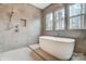 Modern bathroom features a soaking tub with sleek fixtures and three bright windows for natural light at 206 Streamwood Rd # 32, Troutman, NC 28166