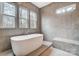 Contemporary bathroom with tub, shower, and three windows allowing abundant natural light at 206 Streamwood Rd # 32, Troutman, NC 28166