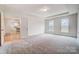 Spacious bedroom with plush carpeting, tray ceiling, and abundant natural light from two large windows at 206 Streamwood Rd # 32, Troutman, NC 28166