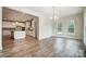 Bright dining room with wood floors flows into an open kitchen with granite counters and white cabinets at 206 Streamwood Rd # 32, Troutman, NC 28166