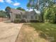 Charming single-story home with well-manicured lawn, tidy shrubbery and concrete driveway leading to the backyard at 211 Sherwood Cir, Rock Hill, SC 29730