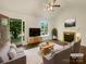 Bright living room featuring a fireplace, hardwood floors, a ceiling fan, and view of the manicured yard at 211 Sherwood Cir, Rock Hill, SC 29730