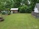 Well-maintained backyard features lush green grass and a storage shed along the fence line at 2213 Milton Rd, Charlotte, NC 28215