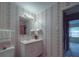 A vintage bathroom with patterned wallpaper, vanity, and a doorway to another room at 2213 Milton Rd, Charlotte, NC 28215