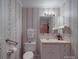 Bathroom featuring floral wallpaper, a white vanity, and convenient grab bars for accessibility at 2213 Milton Rd, Charlotte, NC 28215