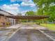 Large carport on a wet driveway with a screened-in back porch visible near the attached home at 2213 Milton Rd, Charlotte, NC 28215