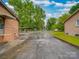 Spacious driveway with fenced yard, brickwork, and detached garage at 2213 Milton Rd, Charlotte, NC 28215